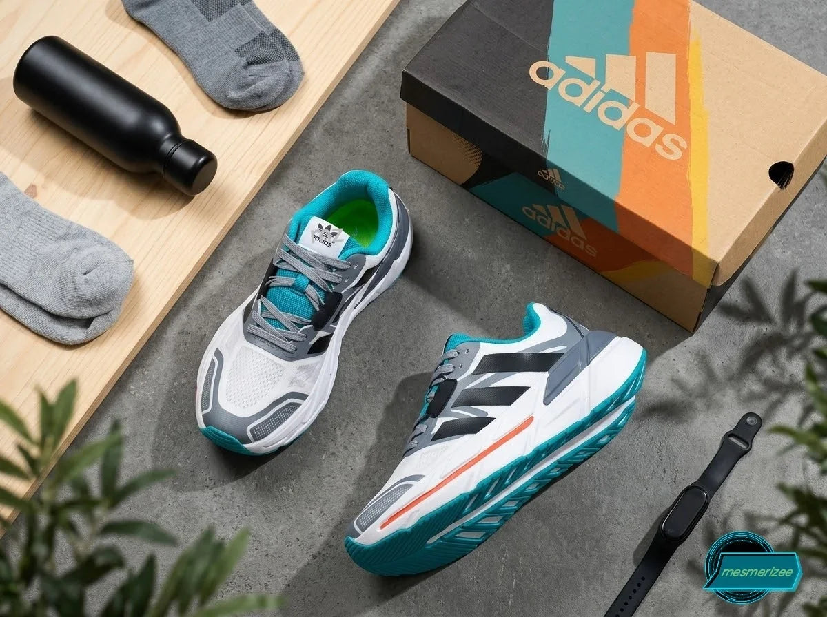 White and grey Adidas running mesh sneakers with a matching box and fitness accessories.