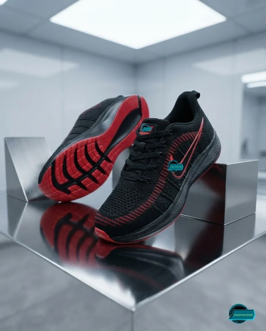 Mesmerizee black premium running mesh sneakers with red sole accents on a reflective surface.