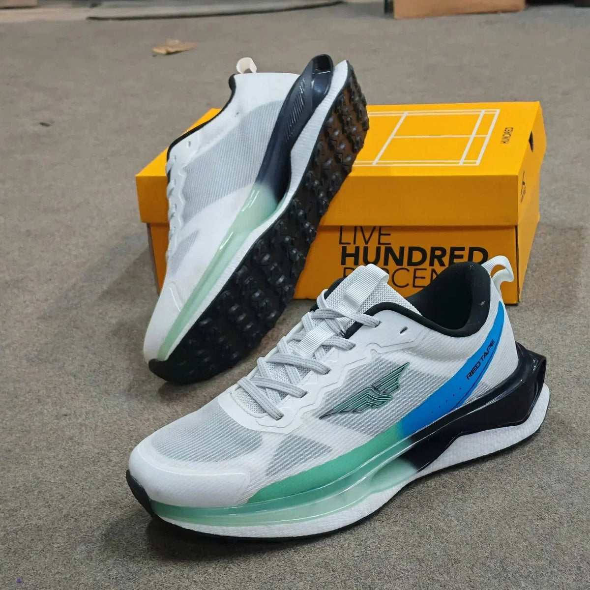 Pair of white Mesmerizeecom premium running mesh sneakers with blue and green accents.